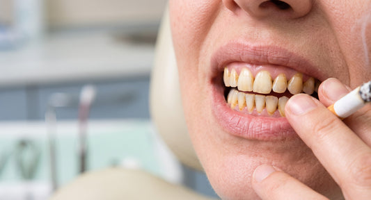 Dents jaunies par le tabac avec une cigarette tenue près de la bouche dans un environnement dentaire professionnel