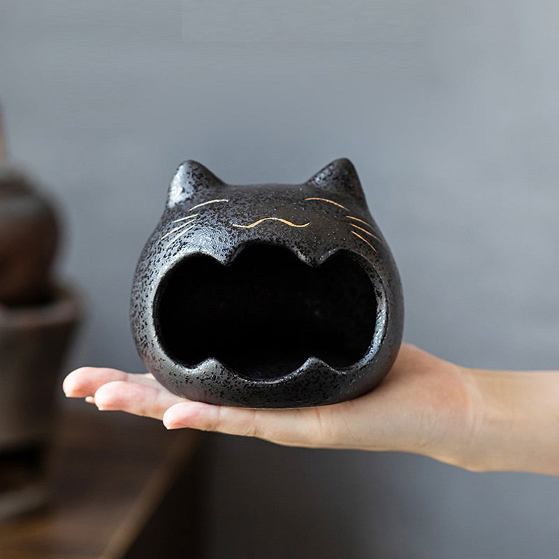 Céramique blanche - cendrier tête de chat tenu dans une main